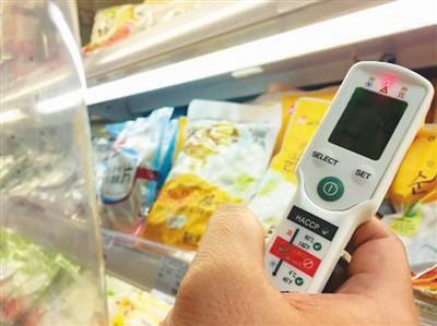 图为执法人员检查超市冷柜的温控系统。