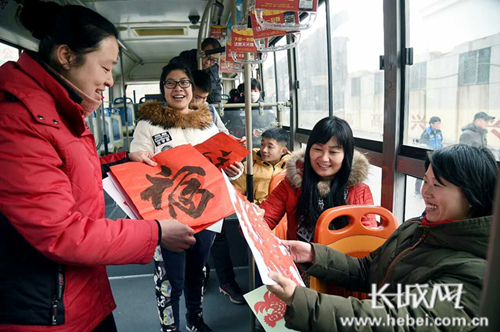 公交志愿者将剪纸送给乘客。