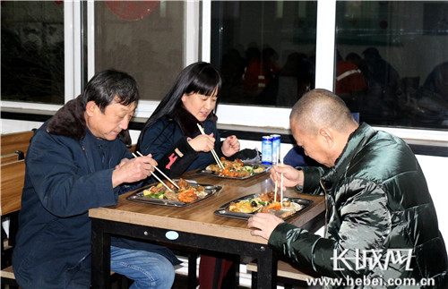 被称为“火车司机B超专家”的机车探伤工李爱凤和同事一起吃年夜饭。