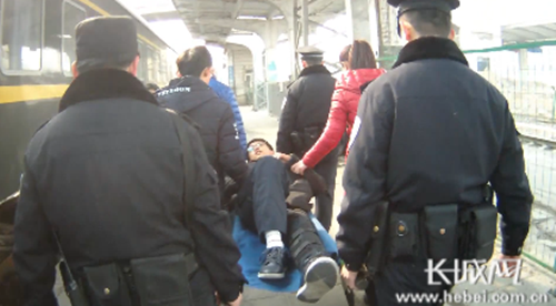 邯郸站派出所民警用担架抬小李出站。