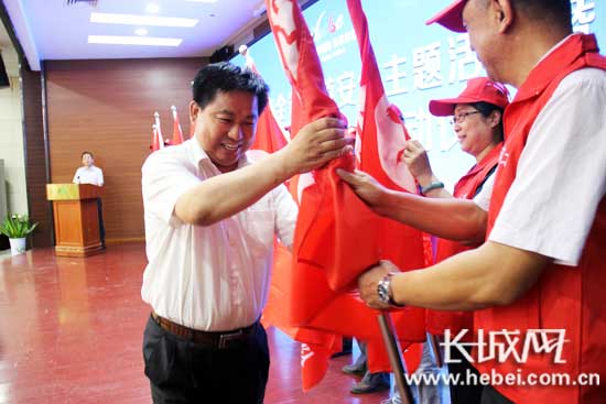 河北省旅游发展委员会副主任赵学锋向志愿者授旗。