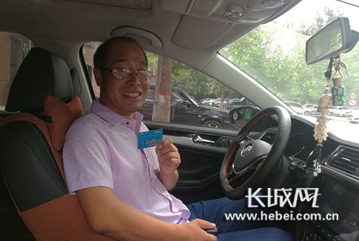  获奖人向记者展示汽油储值卡。图片由河北省公安交管提供