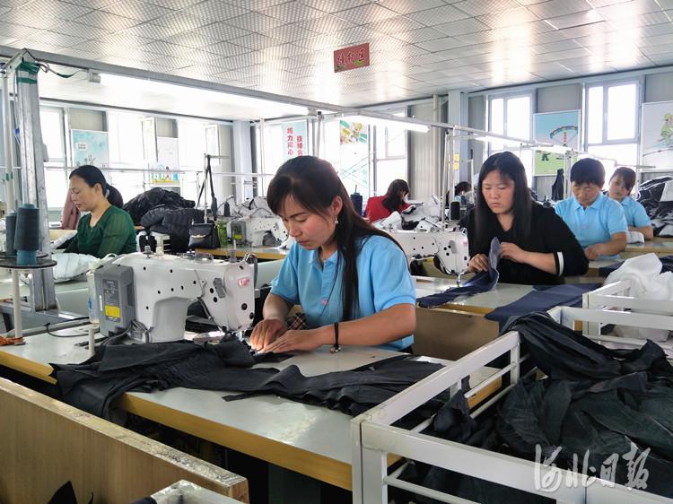 日前,村民们在沙口集乡的"扶贫微工厂—刘屯村服装厂加工服装.