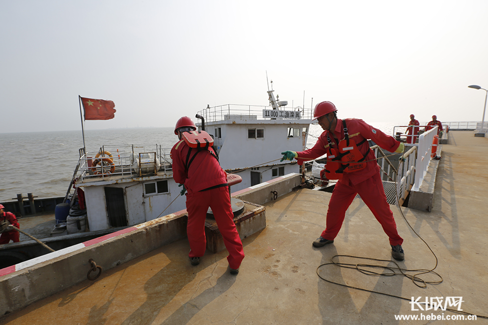 在南堡人工岛码头,冀东油田志达公司码头员工正在带缆接船.