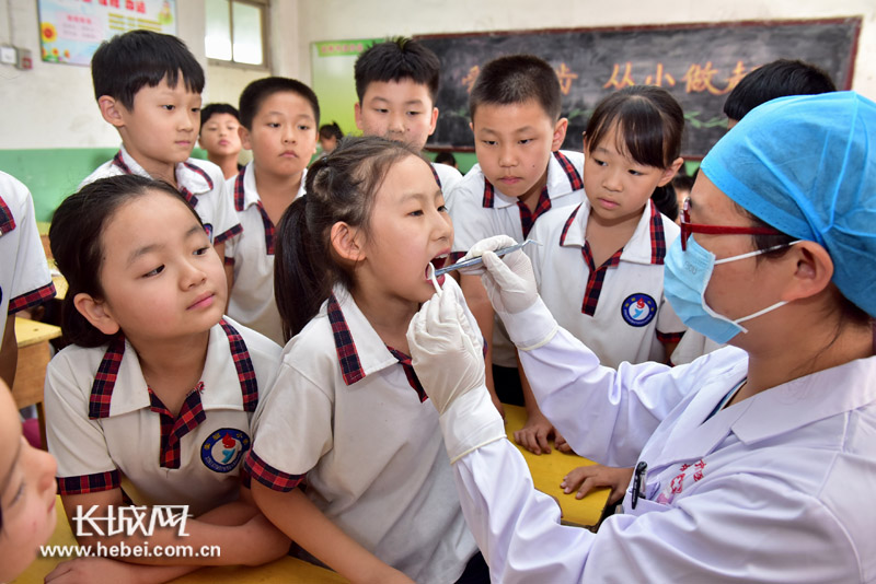 医务人员为小学生检查牙齿.