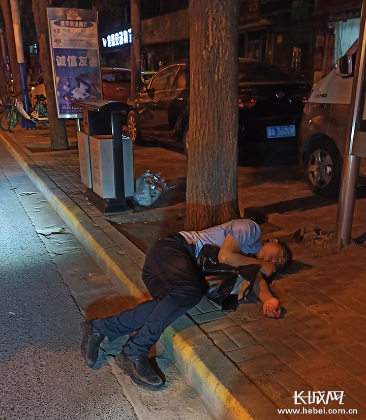 醉酒男子瘫软地横躺在马路和变道间,已经不省人事.张亚肖供图