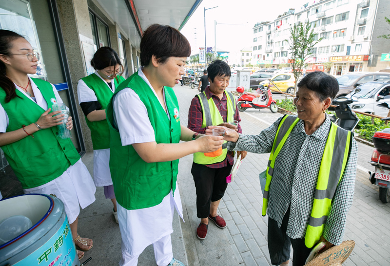 7月23日,湖州市东林镇卫生院的医护人员给环卫工人送上凉茶.