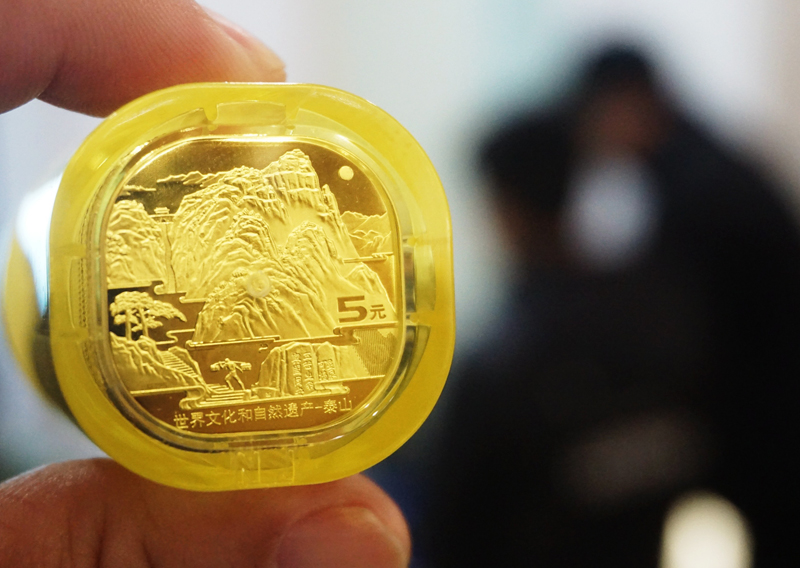 中国首枚异形纪念币泰山币发行 市民排队兑换